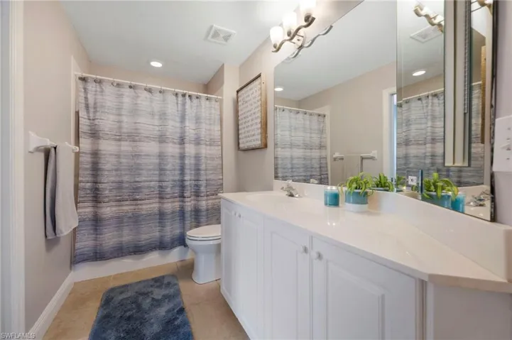 Bathroom with tile flooring, oversized vanity, and toilet