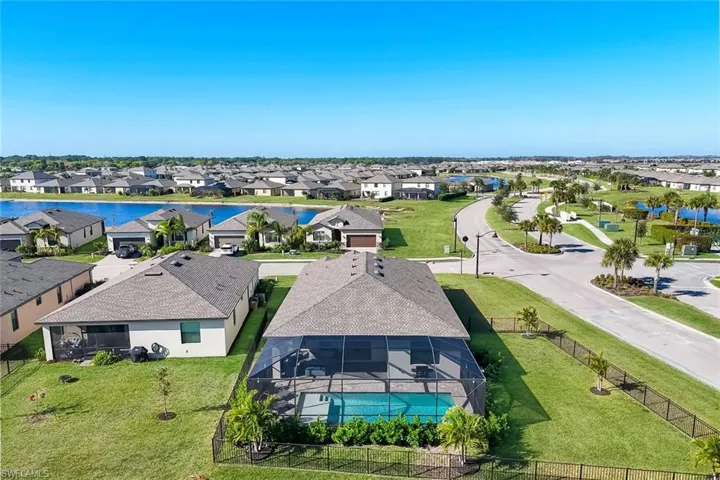 Aerial perspective of suburban area with a large body of water and a pool