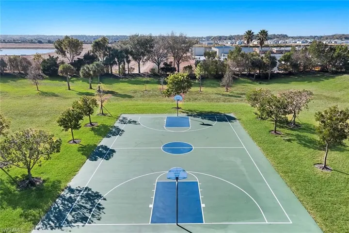 View of sport court with a lawn and community basketball court