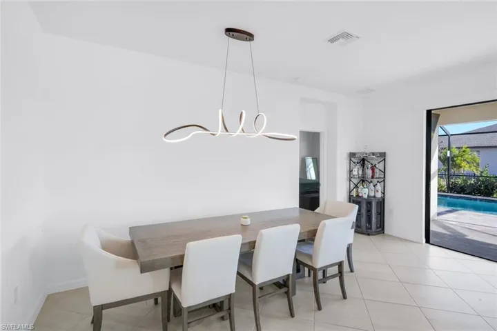 Dining room with hanging lights and light tile patterned flooring