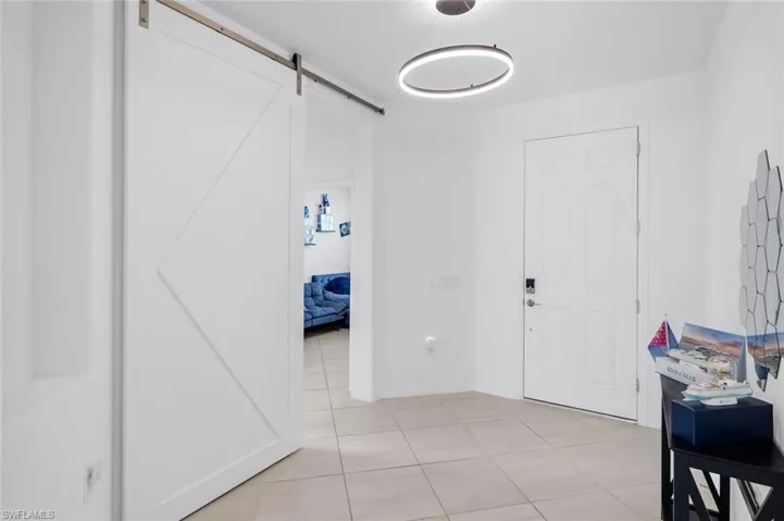 Foyer with a barn door and light tile patterned flooring