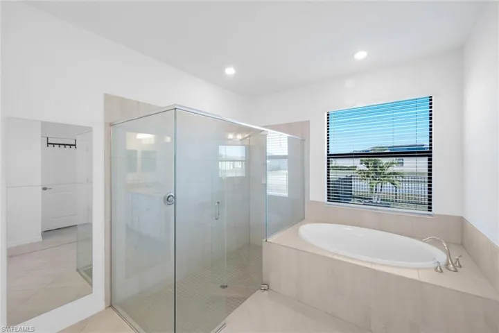 Bathroom featuring a bath, a shower stall, and tile patterned flooring