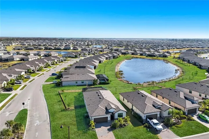 Aerial view of property and surrounding area with nearby suburban area and a large body of water
