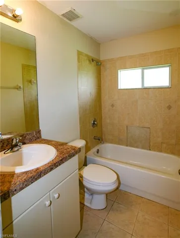 The bathroom features a vanity with a countertop, an integrated sink, and a mirror