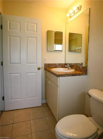 Bathroom with a vanity featuring a granite countertop and an integrated sink, illuminated by an overhead light fixture