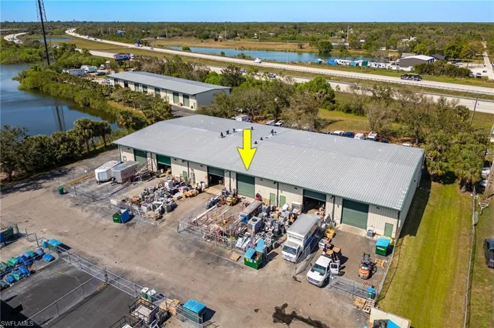 Back fenced in area. Birds eye view of property with a water view