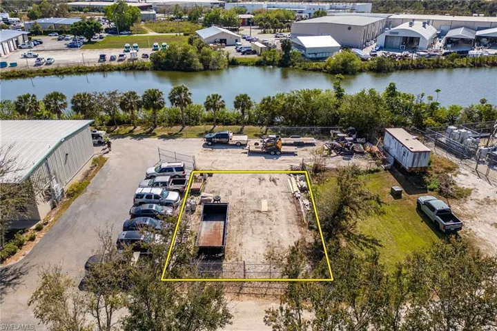 Back fenced in area. Birds eye view of property featuring a water view