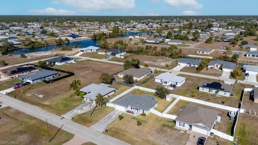 Aerial view of property and surrounding area with nearby suburban area and a nearby body of water