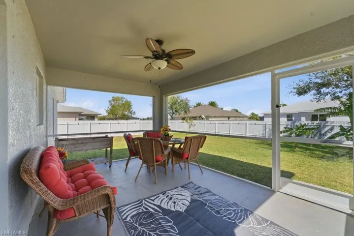 Sunroom / solarium featuring a ceiling fan, outdoor dining area, and a patio