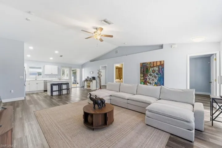 Living area featuring light wood finished floors, a ceiling fan, and recessed lighting