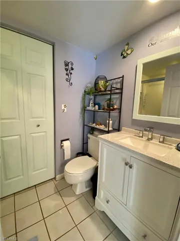 Bathroom featuring vanity, toilet, tile patterned flooring, and a shower