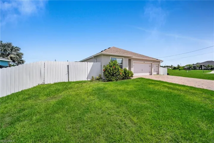 View of front facade featuring decorative driveway, stucco siding, and an attached garage