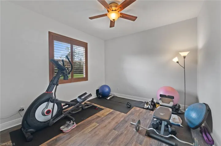Workout area with hardwood / wood-style flooring and ceiling fan
