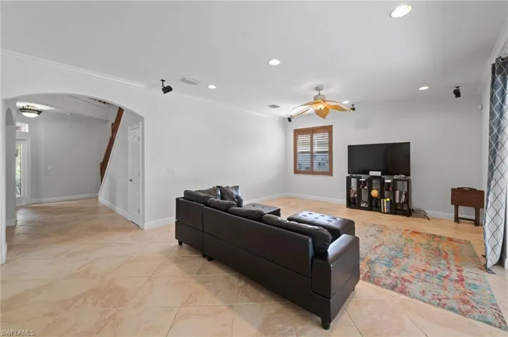 Living room with ceiling fan and ornamental molding