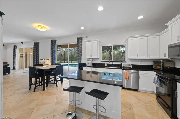 Kitchen featuring white cabinetry, stainless steel appliances, and plenty of natural light