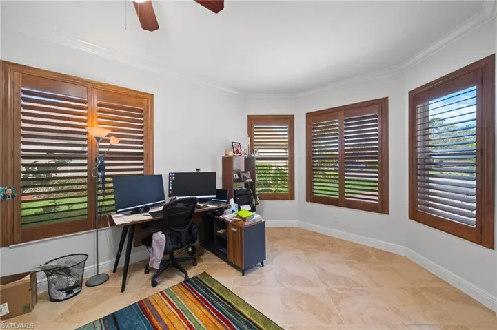 Home office with ceiling fan and ornamental molding