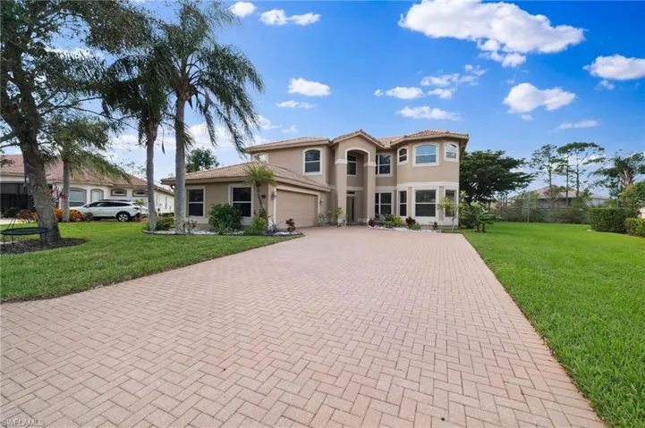 Mediterranean / spanish home featuring a garage and a front yard