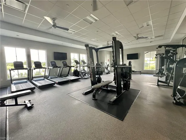 Gym featuring ceiling fan and a drop ceiling
