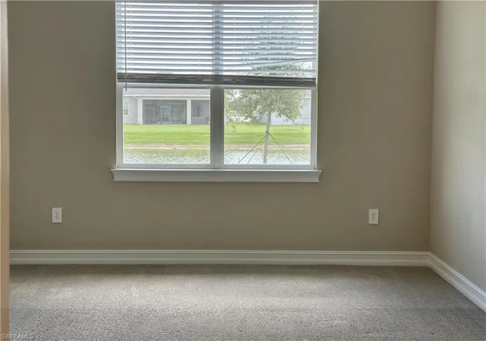 Carpeted empty room with baseboards