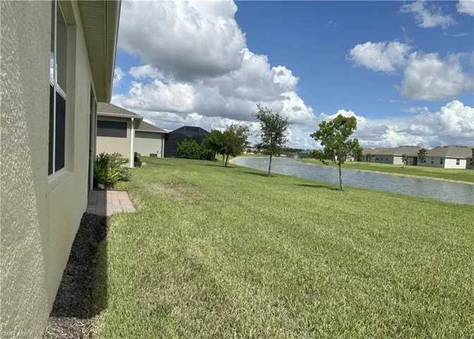 View of green lawn featuring a water view