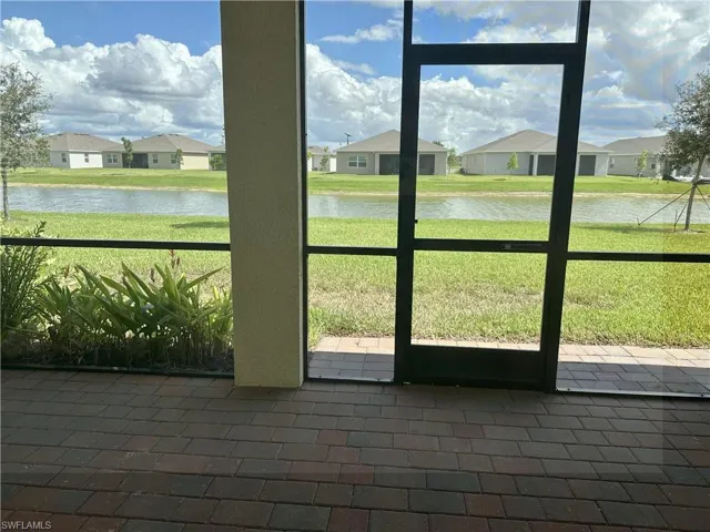 Unfurnished sunroom featuring a water view and a residential view