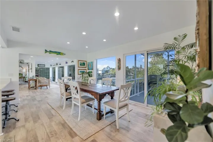 Dining room with light wood-style floors and recessed lighting