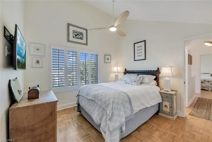 Bedroom featuring parquet floors, lofted ceiling, and a ceiling fan
