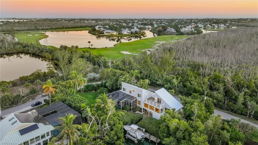 Aerial perspective of suburban area featuring a large body of water and a local golf course