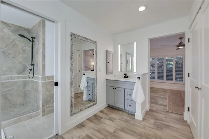 Bathroom with a shower stall, vanity, light wood-style floors, recessed lighting, and ceiling fan