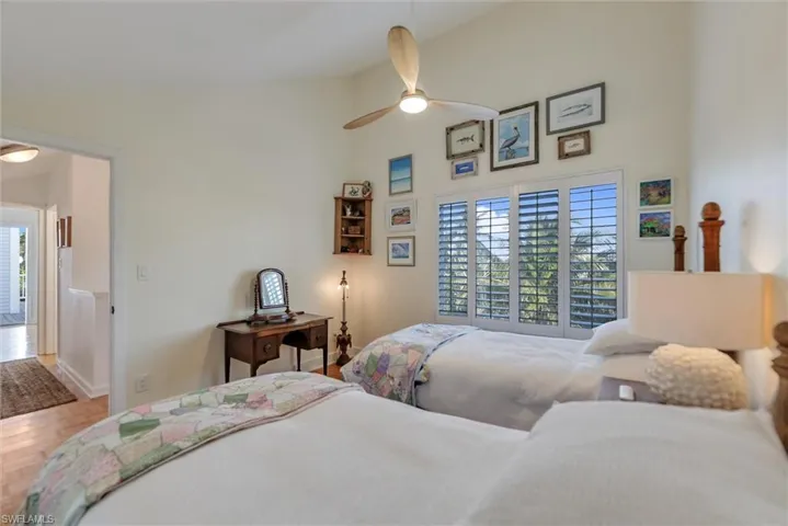 Bedroom featuring lofted ceiling, parquet floors, and a ceiling fan