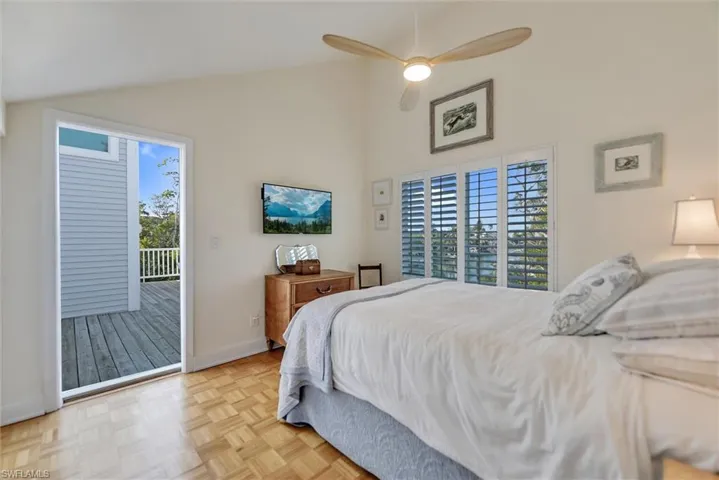 Bedroom with access to exterior, parquet floors, lofted ceiling, and a ceiling fan