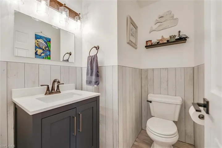 Bathroom featuring vanity, wood finished floors, and wooden walls