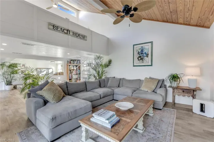 Living area with a ceiling fan, wood finished floors, and a vaulted wood ceiling