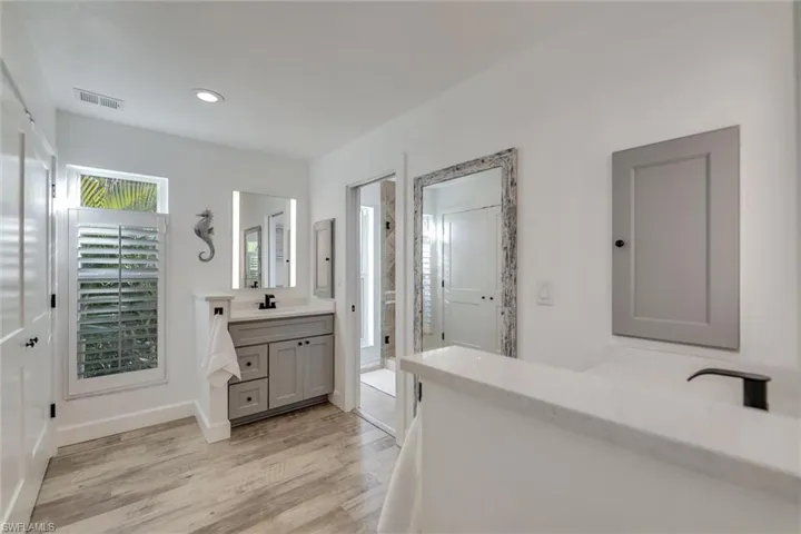 Full bathroom featuring vanity, a stall shower, light wood-type flooring, and recessed lighting