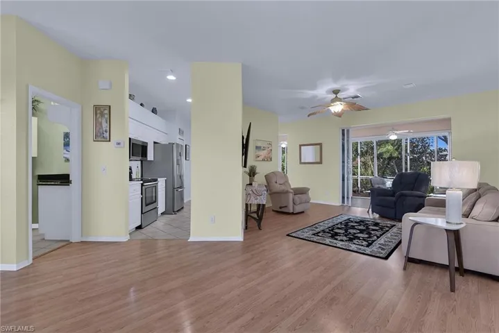 Wood-finish flooring throughout, stainless steel kitchen appliances, ceiling fans, and sliders to the exterior