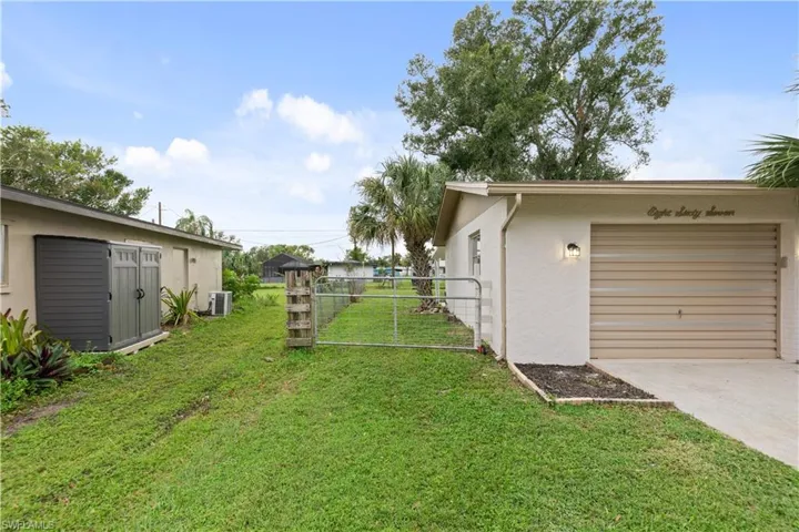 View of yard with central AC and a garage