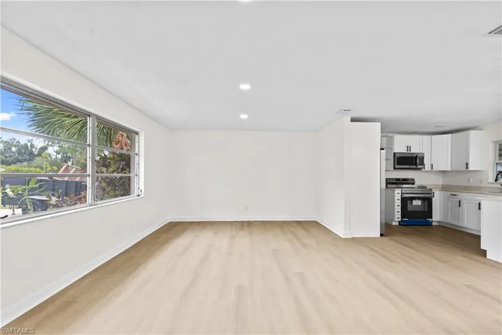 Unfurnished living room with sink and light hardwood / wood-style flooring