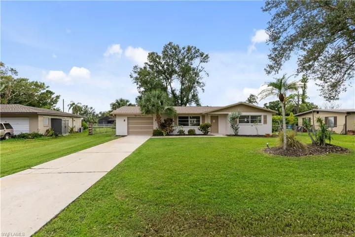 Single story home with a front yard and a garage