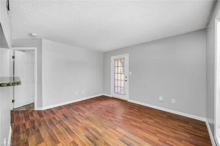 Spare room featuring wood finished floors and a textured ceiling