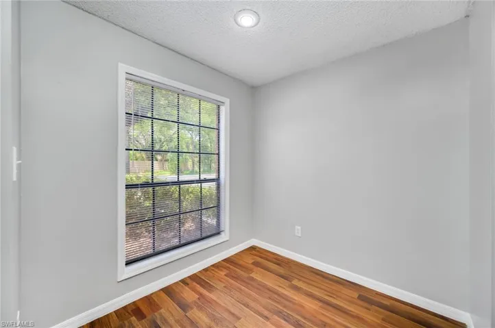 Spare room featuring a textured ceiling and wood finished floors