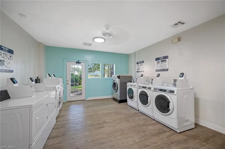 Shared laundry room featuring light wood-type flooring, washing machine and dryer, and ceiling fan