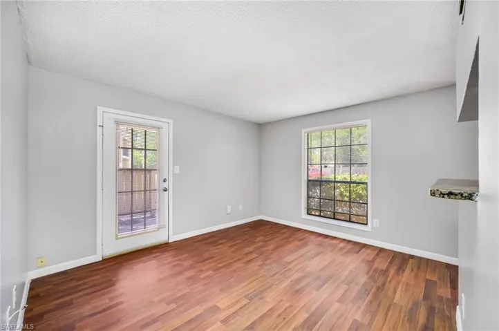Unfurnished room with wood finished floors and a textured ceiling