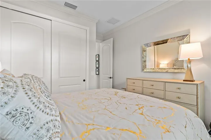 2nd Bedroom with ornamental molding, visible vents, and a closet