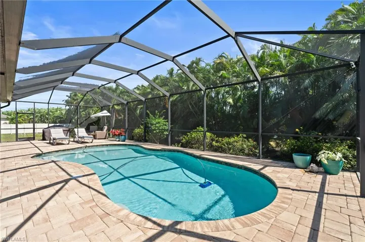 Outdoor pool with a patio area and glass enclosure