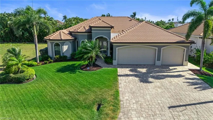 Mediterranean / spanish home featuring stucco siding, decorative driveway, an attached garage, a front yard, and a tile roof