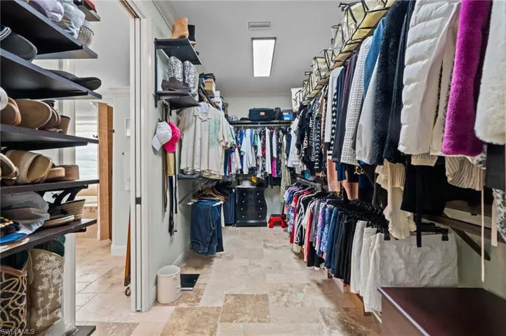 Spacious closet featuring stone finish floor and visible vents