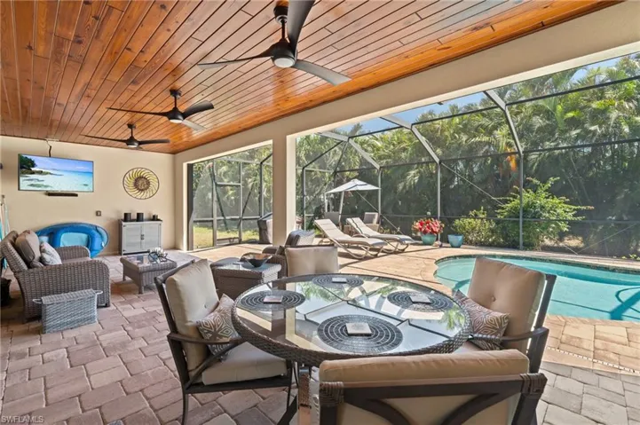 View of patio featuring an outdoor living space, an outdoor pool, glass enclosure, and a ceiling fan
