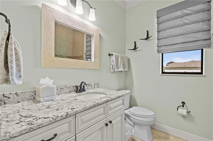 2nd Bathroom featuring toilet, vanity, baseboards, and ornamental molding