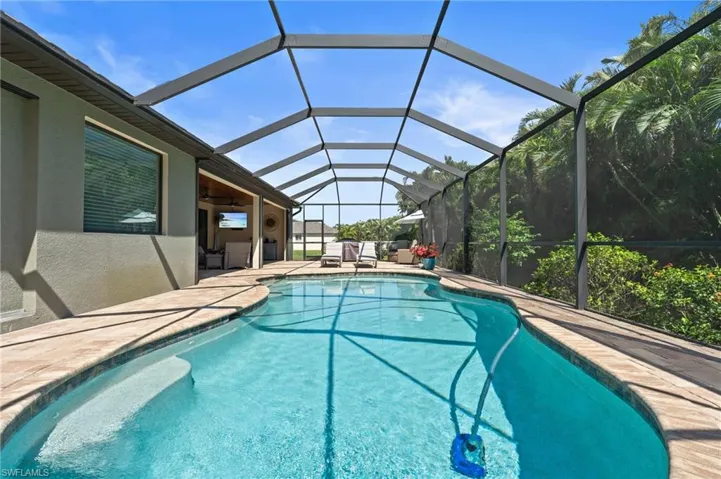 Outdoor pool with a patio and glass enclosure
