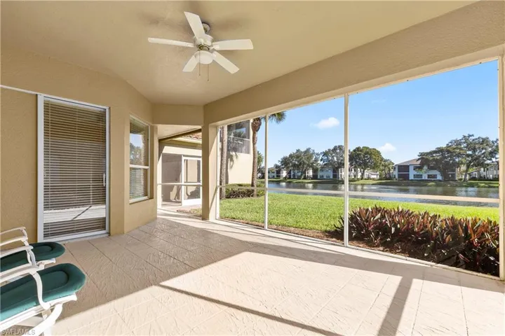Unfurnished sunroom with a ceiling fan and a water view
